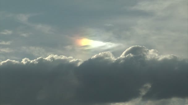 Słońce, wpatrując się przez duży biały chmury burzowe — Wideo stockowe