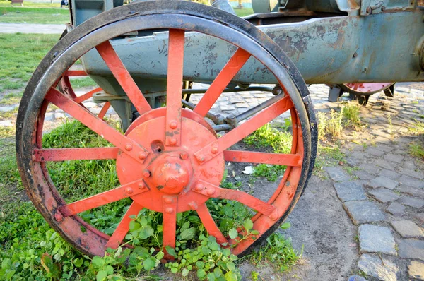 Vecchia ruota di ferro rosso fuso nell'erba — Foto Stock