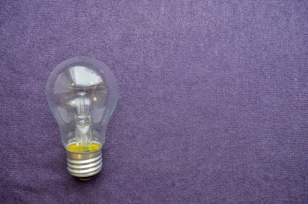 Круглая Обычная Неэкономичная Лампа Накаливания Прозрачном Цокольном Фоне Фиолетовой Ткани — стоковое фото