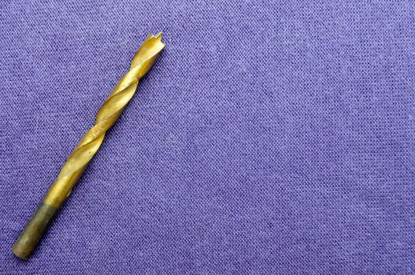 Желтая Золотая Медная Дрель Дереве Фоне Фиолетовой Ткани Дрель Сверла — стоковое фото