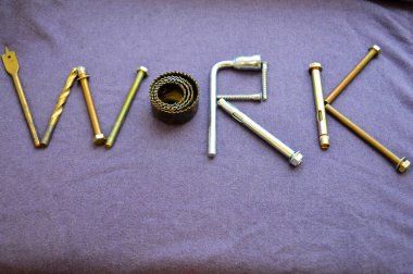 Yazıt iş metal çapa cıvata, vida, svermami, anahtarı bulunmakta. Nesnelerinden oluşan bir çalışma. İş sözcük metal işleri aracı mor bir arka plan üzerinde oluşur.