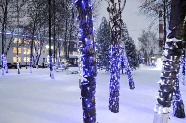 Noel lambaları ve Çelenkler, Noel süslemeleri ve fabrika boruları ağaçlar gövdeleri. İş yerinde Noel.