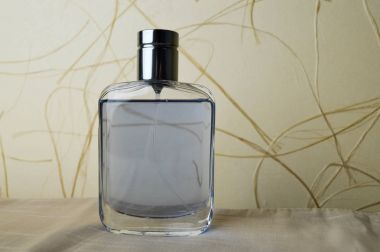 Köln, tuvalet suyu, kuru ot ile bej duvar kağıdı arka plan üzerinde parfüm mavi, güzel, cam şişe.