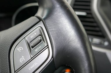 Siyah deri direksiyon simidi arabanın hız kontrol düğmeleri.