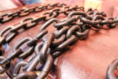 Kalın, güçlü, demir, eski zincirleri ahşap kahverengi gövde arka planı.