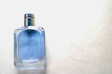 Mavi dikdörtgen güzel cam şeffaf parlak moda göz alıcı kolonya şişesi, gümüş çerçeveli parfüm ve gri ışık arka plan üzerinde örnek metin için yer