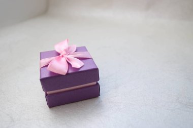 Menekşe hediye güzel festival karton küçük hediye kutusu ışık gri arka plan üzerinde bir yay ile. Arka plan.