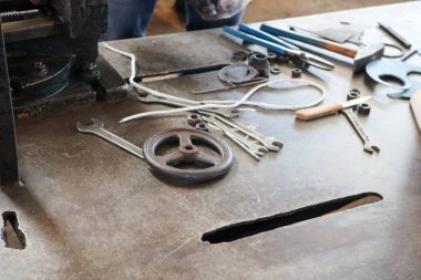 Metal işleri aracı, anahtarı, çekiç, tornavida, kerpeten, bıçak, subaplar fabrikada, bir fabrika ile bir demir tablo. Kavram işyeri sanayi.
