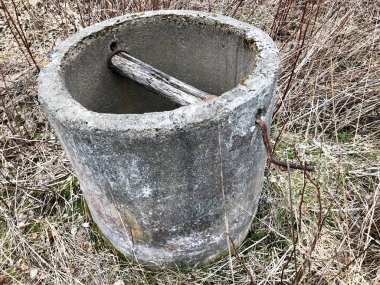 Eski vintage terk edilmiş gri beton, çimento paramparça derin sonbaharda ormandaki içme suyu ile iyi.