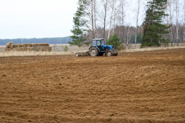 Mavi traktör, agrimotor sows bitkileri, tarım, tarım, tarım, toprak sahada çalışan gerçekleştirir.