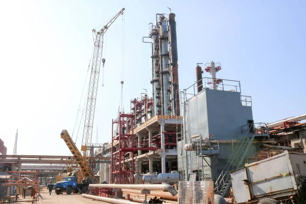 Construction site for the construction of an oil refinery, installation of rectification columns, heat exchangers, pipelines, a crane at an oil refinery, a petrochemical plant.