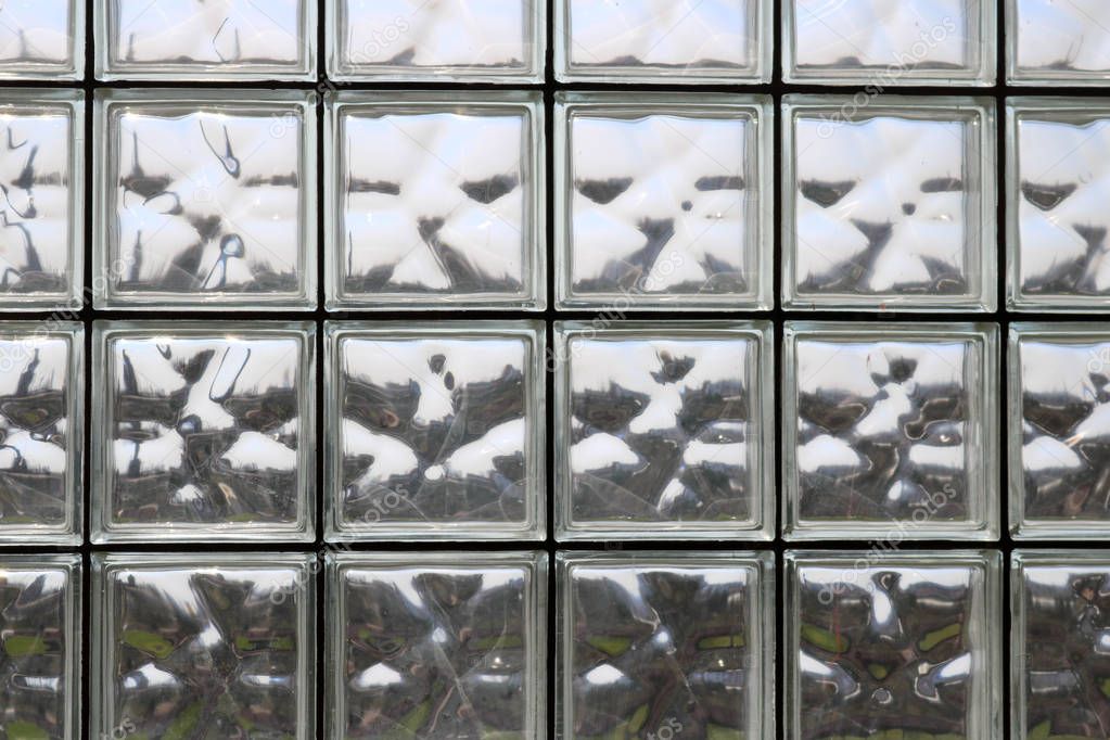 Texture of many shiny transparent beautiful square thick glass tiles with seams background