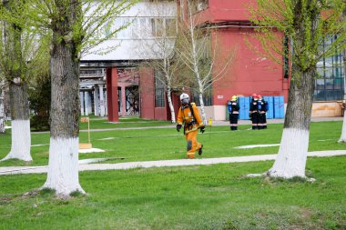 Profesyonel itfaiyeciler, insan bir yangın hortumu, bir hortum ile tehlikeden kurtarmak için kurtarma ekipleri yangına dayanıklı koruyucu giysiler, kask ve oksijen şişe ile gaz maskeleri hazırlanır.
