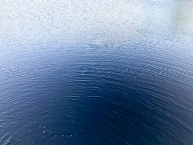 Mavi güzel su ve dairesel dalgalar waterdish yamalar, kabarcıklar ve sprey aşağıdan, arka plan doku.