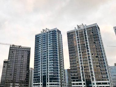 Uzun ve güzel monolitik çerçeve binalar, yeni binalar, gökdelenler, cam ve betondan yapılmış evler şehrin yeni bölgesinde birçok pencereye sahip. Arkaplan