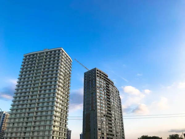 Hohe monolithische Plattenbauten, Neubauten, Wolkenkratzer, Häuser aus Glas und Beton mit vielen Fenstern im neuen Viertel der Stadt. Die Vorgeschichte — Stockfoto