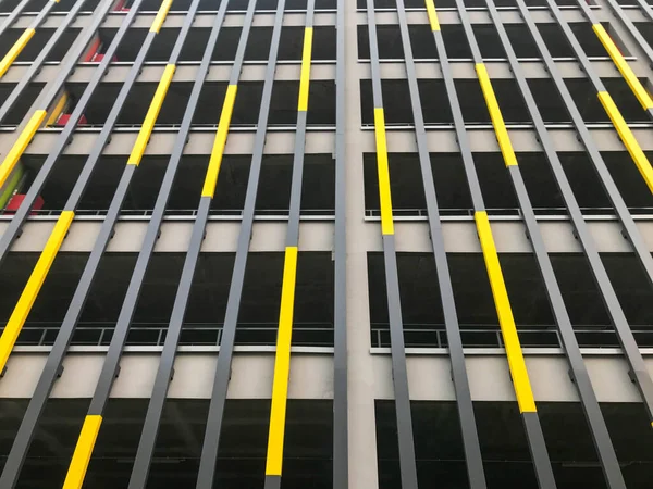 La textura de la pared de la izquierda y la derecha palos verticales decorativos de las tablas de los paneles amarillo y gris. Decoración decorativa de la fachada del edificio. El trasfondo — Foto de Stock