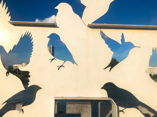 A kék ég előtt fémből faragott madárgalambok absztrakt sziluettjei — Stock Fotó