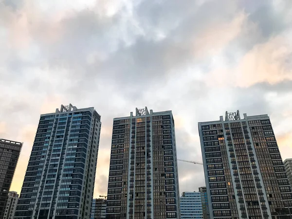Höga vackra monolitiska ram panelbyggnader, nya byggnader, skyskrapor, hus av glas och betong med många fönster i den nya stadsdelen i staden. Bakgrund — Stockfoto