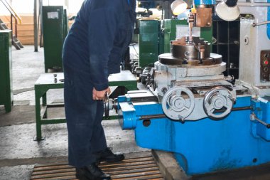 Büyük metal endüstrisi dönüyor ve metal işlemek için vida kesme makinesi ve yedek parça ve fabrikada bornoz bir işçi