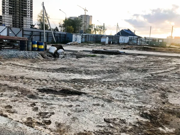 Vista interior de una gran obra de construcción industrial detrás de una valla con herramientas, cañones y materiales de construcción sobre los que se están construyendo nuevas casas. — Foto de Stock