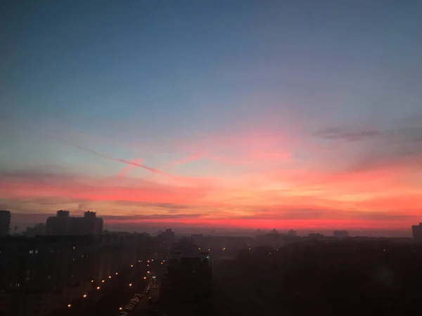 Alvorada vermelha bonita do sol em uma metrópole de cidade grande com edifícios e nuvens. A vista da altura — Fotografia de Stock