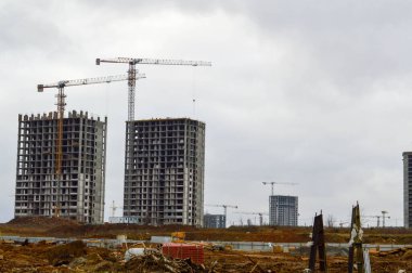 Endüstriyel inşaat ekipmanları ve büyük vinçler kullanılarak büyük modern monolitik çerçeve evler inşa ediliyor. Binanın inşaatı şehrin yeni mikro bölgesinde.