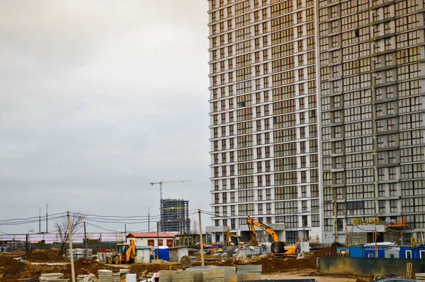 Construction of large modern monolithic frame houses, buildings using industrial construction equipment and large high cranes. Construction of the building in the new micro district of the city