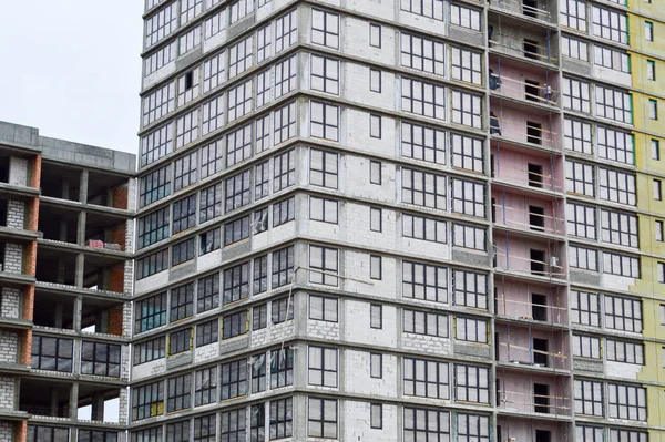 Gran cemento de hormigón moderno en construcción nuevo edificio monolítico moderno con ventanas, paredes y balcones — Foto de Stock