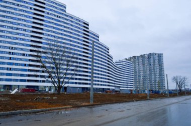 Yapım aşamasındaki büyük beton modern pencereleri, duvarları ve balkonları olan modern, tek katlı bina.