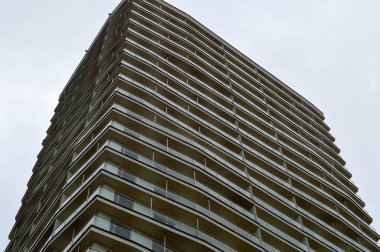 Yapım aşamasındaki büyük beton modern pencereleri, duvarları ve balkonları olan modern, tek katlı bina.