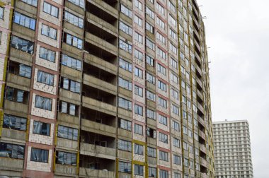 Yapım aşamasındaki büyük beton modern pencereleri, duvarları ve balkonları olan modern, tek katlı bina.