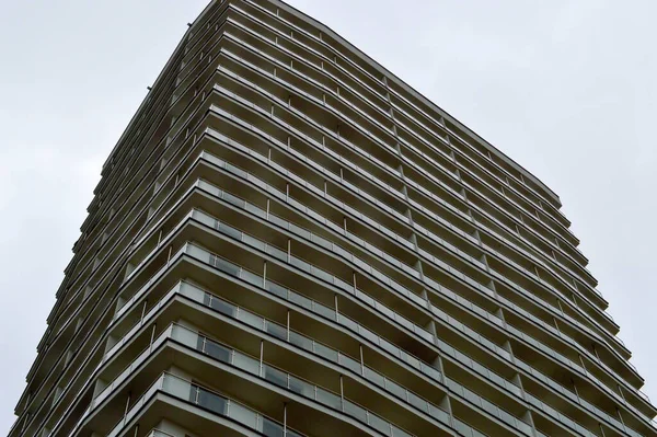 Gran cemento de hormigón moderno en construcción nuevo edificio monolítico moderno con ventanas, paredes y balcones — Foto de Stock