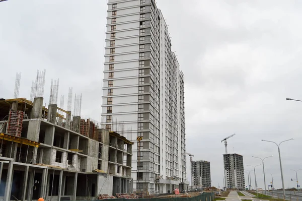 Construction of large modern monolithic frame houses, buildings using industrial construction equipment and large high cranes. Construction of the building in the new micro district of the city