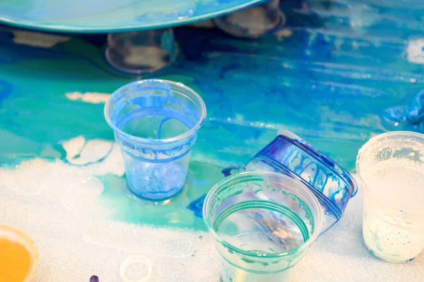 Процес створення домашнього модного абстрактного сучасного візерунка, пофарбованого пензлем акрилової блакитної різнокольорової смоли на круглій дерев'яній дошці — стокове фото