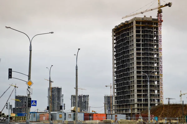 Construction of large modern monolithic frame houses, buildings using industrial construction equipment and large high cranes. Construction of the building in the new micro district of the city