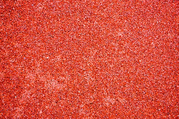 Red bright soft rubber flooring safe for sports and workout or on the playground from the many small round pebbles pressed. Background, texture — 스톡 사진