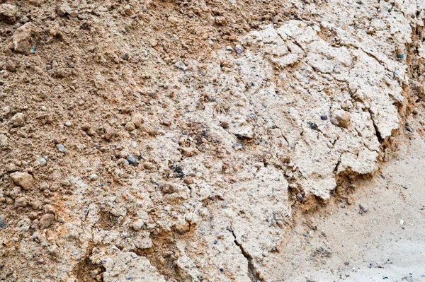 Uitzicht op bruin gebarsten natuurlijke vochtige aarde klei. De achtergrond. Textuur — Stockfoto