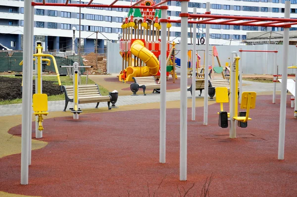 New modern safe outdoor playground in the open air with exercise equipment and toys in a new district of the city in the courtyard of a new building