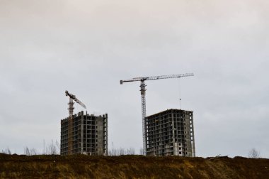 Endüstriyel inşaat ekipmanları ve büyük vinçler kullanılarak büyük modern monolitik çerçeve evler inşa ediliyor. Binanın inşaatı şehrin yeni mikro bölgesinde.