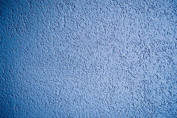 Ściana niebieskiego szorstkiego tłoczonego budynku dekoracyjnego stiuku. Tekstura, tło — Zdjęcie stockowe