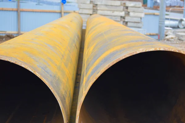 Large iron metal sewer plumbing pipes of large diameter for the industrial construction of water supply or sewage at a construction site during the repair — Stock Photo, Image