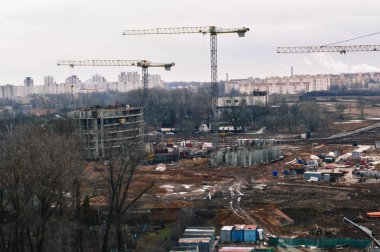 Büyük şehirlerde büyük sanayi vinçleri ve profesyonel ekipmanların yardımıyla yüksek binaları olan yeni bir konut inşaatı sırasında inşaat alanının en üst görüntüsü