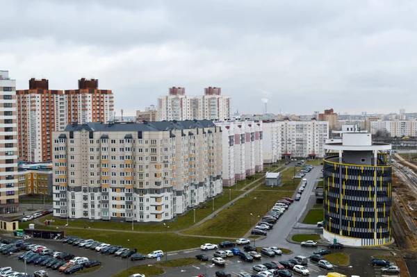 Вид сверху на большой современный город с домами, многоэтажными зданиями и архитектурой, парковкой и большим количеством автомобилей — стоковое фото