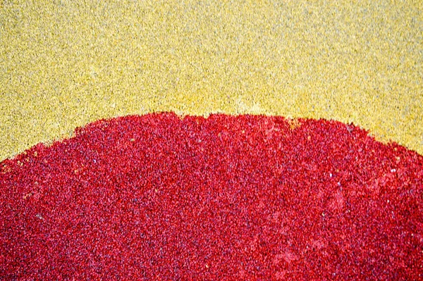 Желтые и красные ярко-мягкие резиновые полы безопасны для спорта и тренировок или на детской площадке из множества маленьких круглых булыжников. Фон, текстура — стоковое фото