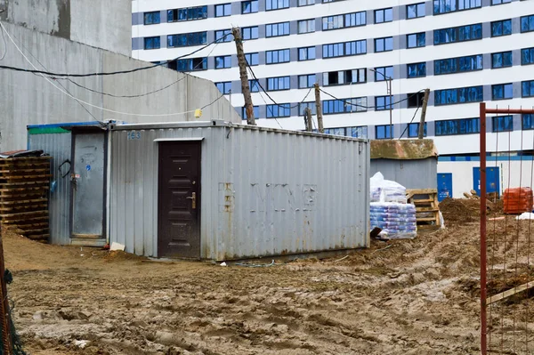 Small temporary houses of builders from containers at an industrial construction site. Block-modular construction city with change houses for workers