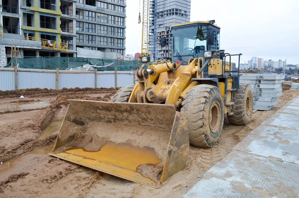 Big kuning cerah kuat industri traktor berat, buldoser, alat konstruksi khusus untuk perbaikan jalan selama pembangunan baru mikro-kabupaten di kota besar — Stok Foto