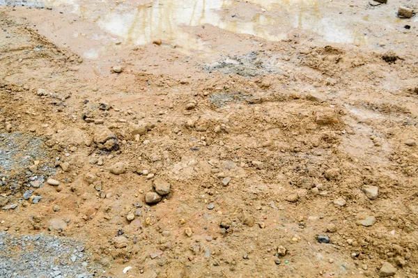 Textura de uma estrada de terra suja má sujeira com poças e argila lama de secagem com rachaduras e ruts. Fora de estrada. O fundo — Fotografia de Stock