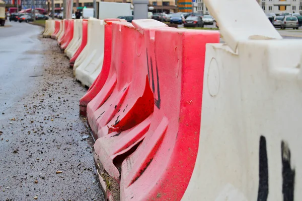 Suuret muovi punainen ja valkoinen kotelo lohkot täynnä vettä liikenneturvallisuuden aikana teiden korjaukset — kuvapankkivalokuva