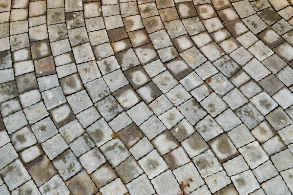 Szary kamienny chodnik wykonany z betonu kwadratowe ukośne płyty chodnikowe z szwami. Tekstura, tło — Zdjęcie stockowe
